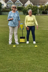 Two woman standing on a field playing a game