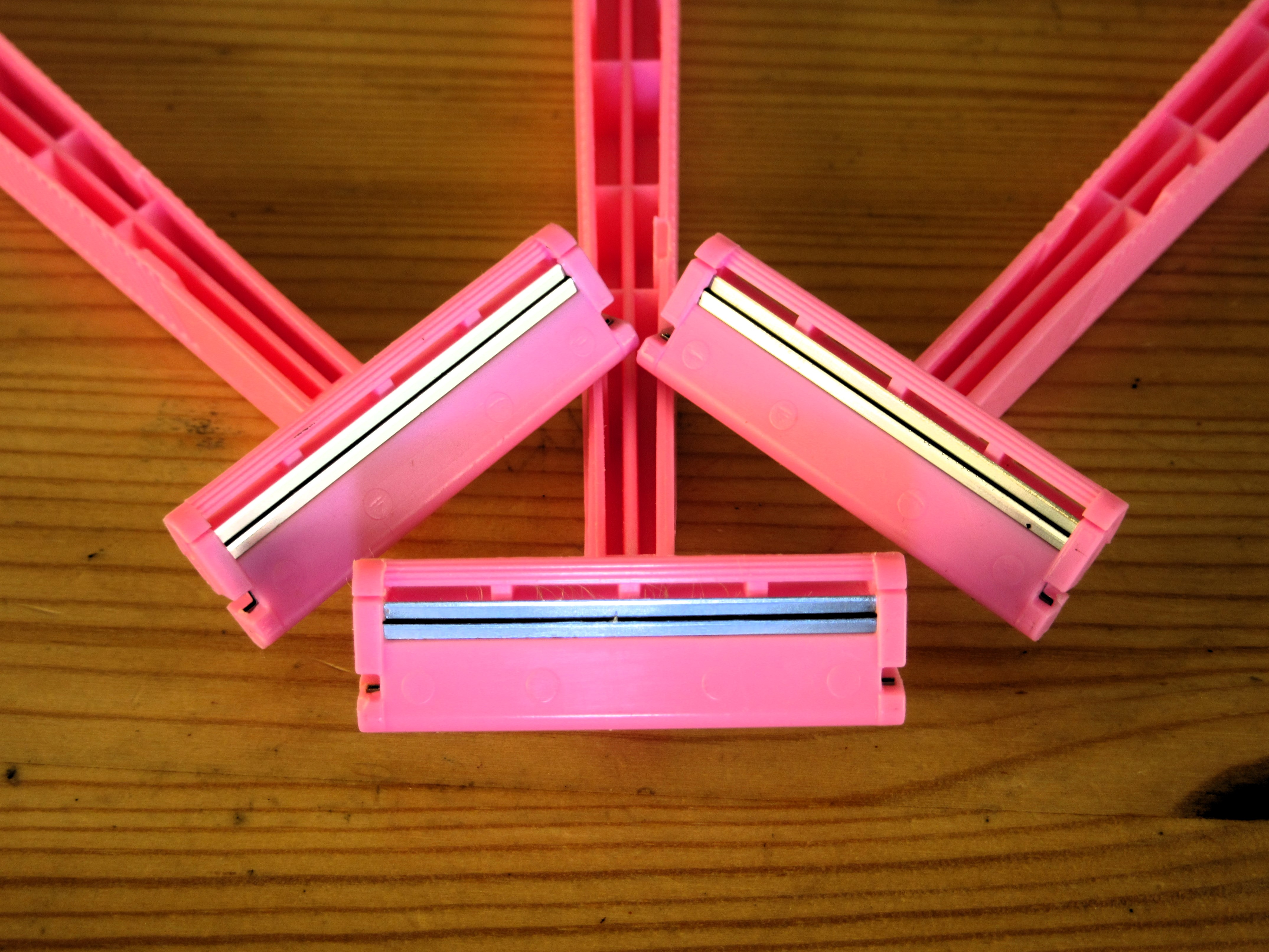 Photo of the heads of three pink razors