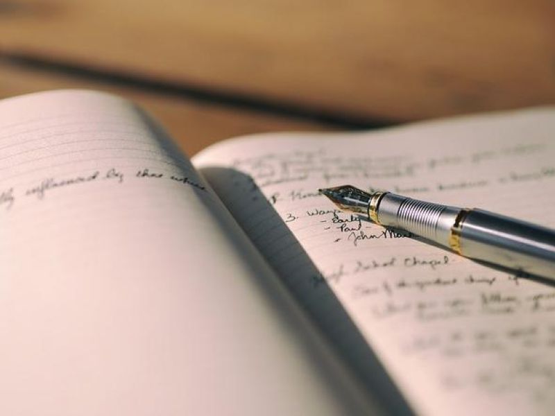 pen open with writing and book 