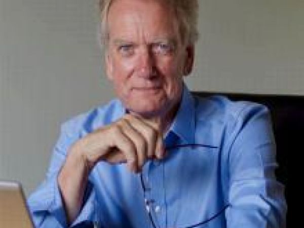 man in blue shirt in front of laptop
